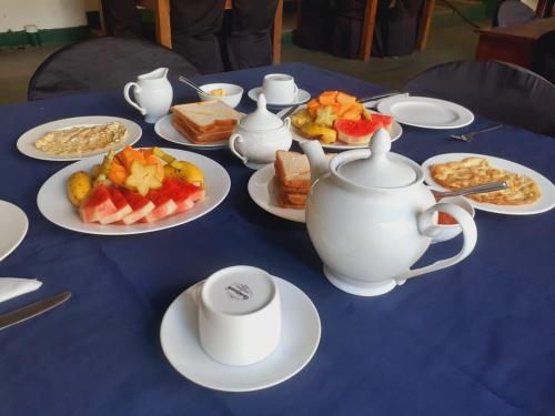 uma mesa azul com pratos de comida e bules de chá em New Isuru City em Dambulla