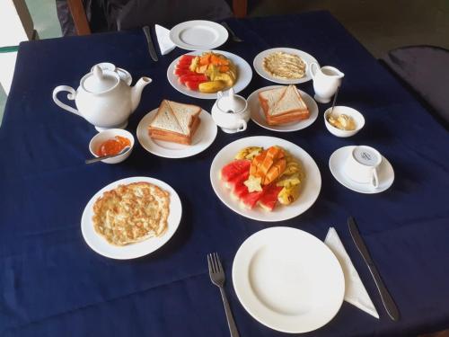 uma mesa azul com pratos de comida para o pequeno almoço em New Isuru City em Dambulla