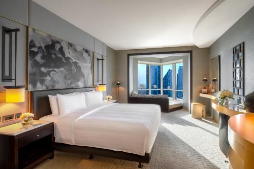a bedroom with a large white bed and a large window at Shangri-La Dubai in Dubai