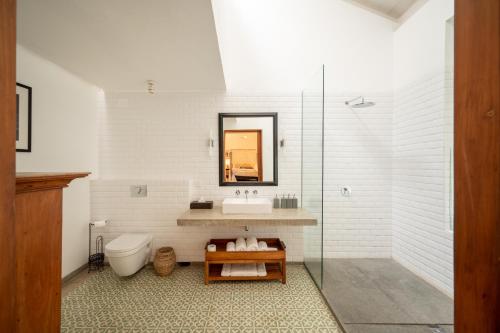 a bathroom with a sink and a toilet and a mirror at 41 Lighthouse Street in Galle
