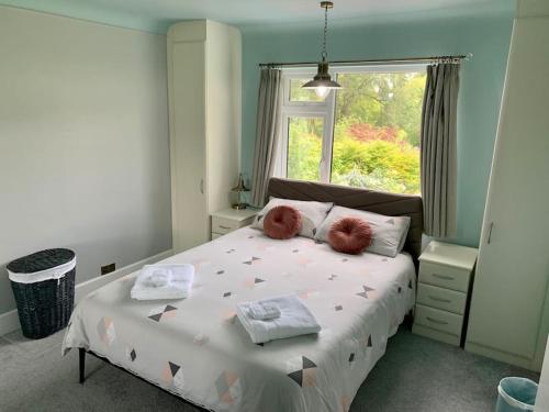 a bedroom with a bed with two pillows and a window at Modern 3 Bedroom Home in Coy Pond, Poole in Parkstone