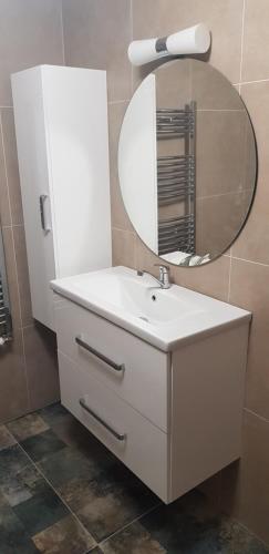 a bathroom with a white sink and a mirror at Apartmán Greenside in Michalovce