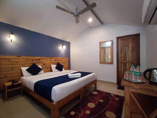a bedroom with a large bed with a blue wall at Pebbles Resort in Rishīkesh