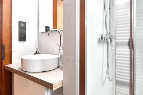 La salle de bains est pourvue d'un lavabo blanc et d'une douche. dans l'établissement Appartement de 3 chambres avec jardin clos et wifi a Thannenkirch, à Thannenkirch