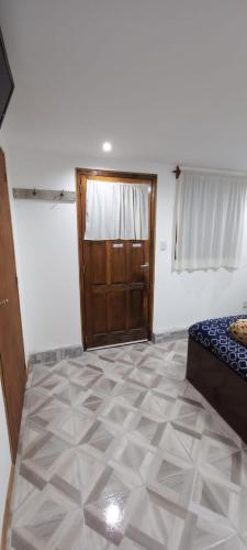 Habitación con dormitorio con puerta y suelo de baldosa. en Alojamiento Los hermanos en Ushuaia