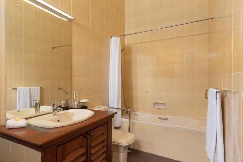 a bathroom with a sink and a toilet and a shower at Jetwing Uva Ben Head Villa in Welimada