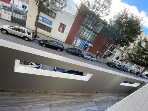 an overhead view of cars parked on a city street at Costa Paradise Beach in Costa da Caparica