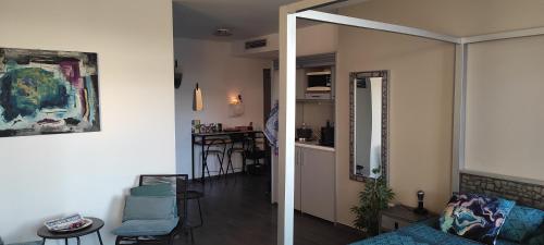 a living room with a couch and a dining room at grand studio terrasse de standing, pleine vue village et proche mer in Carry-le-Rouet