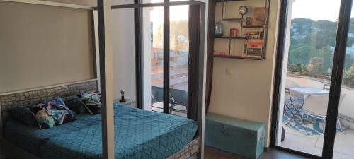 a bedroom with a mirror and a bed and a balcony at grand studio terrasse de standing, pleine vue village et proche mer in Carry-le-Rouet
