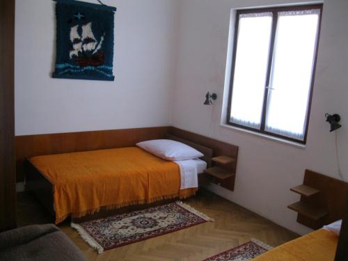 a small room with a bed and a window at Apartments Maria in Supetar