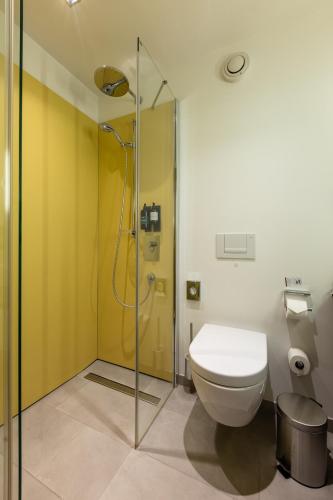 a bathroom with a toilet and a glass shower at Hotel Wirtshaus Post in Sankt Johann in Tirol