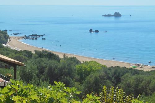 a view of a beach with people in the water at Studio Apartment with adult and childrens pool and sea view - Pelekas Beach in Pelekas