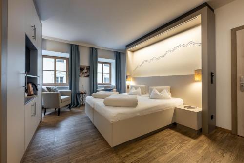 サンクト・ジョアン・イン・チロルにあるホテル ヴィルツハウス ポストのベッドと大きな窓が備わるホテルルームです。