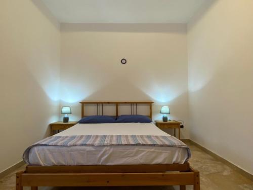 a bedroom with a bed with two nightstands and two lamps at La Perugina in Gallipoli