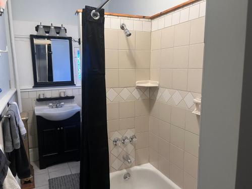 ein Badezimmer mit einer Badewanne und einem Waschbecken in der Unterkunft 1 Br Private Victorian Apt in convenient City location on 5 acre, sleeps 4 in Poughkeepsie