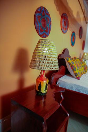 a lamp on a table in a room with a bed at Tea House BNB in Kigali