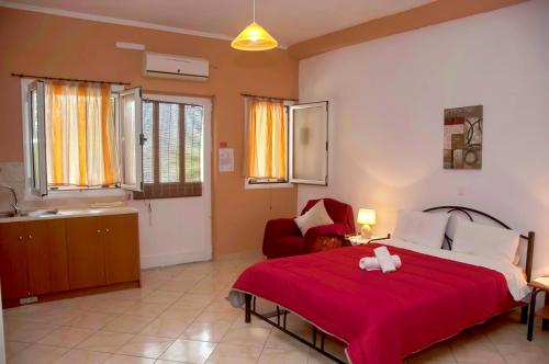 a bedroom with a large bed with a red blanket at Holiday Studio Apartment Tonia - Pelekas Beach, Corfu in Pelekas