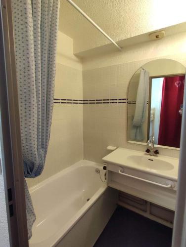 une salle de bain avec une baignoire, un lavabo et un miroir dans l'établissement Studio centre station - vue magnifique - Valfréjus, à Modane