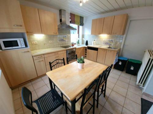 eine kleine Küche mit einem Holztisch und Stühlen in der Unterkunft Le refuge de la hoegne in Solwaster