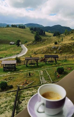 a cup of coffee sitting on a table next to a window at Pensiunea Crai Nou in Şirnea