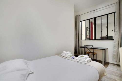une chambre blanche avec un lit et une fenêtre dans l'établissement Modern apartment - 2BR-6P - Arts et Métiers, à Paris