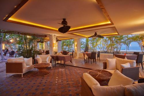 a restaurant with couches and tables and a view of the ocean at Dreams Jardin Tropical Resort & Spa in Adeje