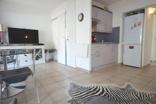 une cuisine avec des armoires blanches, un bureau et une télévision dans l'établissement Nice 2 Rooms Cannes Center, à Cannes