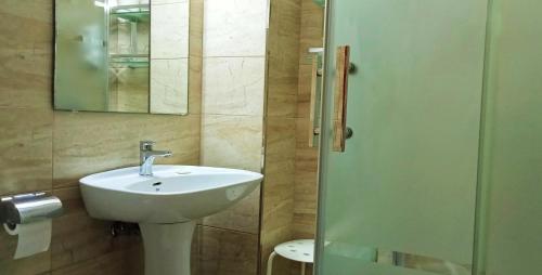 y baño con lavabo, espejo y ducha. en Hostal Bahía, en Cádiz