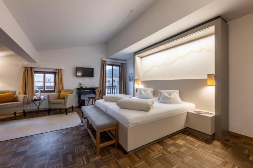 a bedroom with two beds and a living room at Hotel Wirtshaus Post in Sankt Johann in Tirol