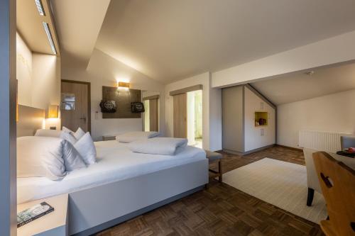 a bedroom with a large white bed in a room at Hotel Wirtshaus Post in Sankt Johann in Tirol