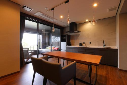 a kitchen and dining room with a wooden table and chairs at Arima Onsen Taketoritei Maruyama in Kobe