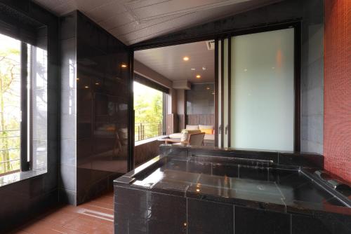 a bathroom with a large window and a bath tub at Arima Onsen Taketoritei Maruyama in Kobe