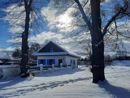 una casa blanca con una cerca en la nieve en Apartmány Máša en Liptovský Trnovec