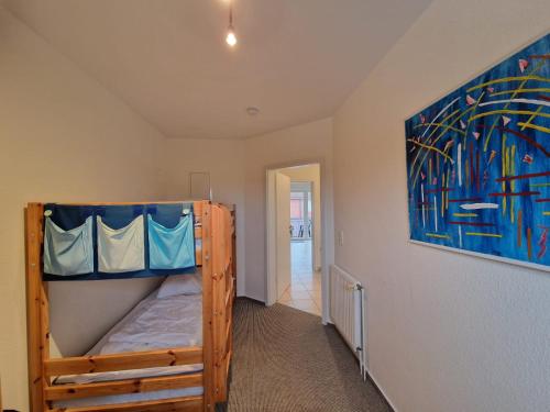 a bedroom with a bunk bed and a painting on the wall at Ferienwohnung Rieke in Norddeich