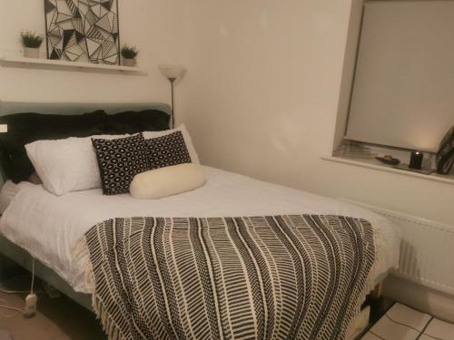 a bedroom with a bed with a black and white blanket at Private kingsize room in Shinfield