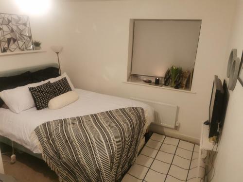 a small bedroom with a bed and a mirror at Private kingsize room in Shinfield