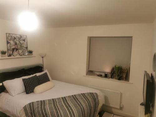 a bedroom with a bed and a mirror on the wall at Private kingsize room in Shinfield