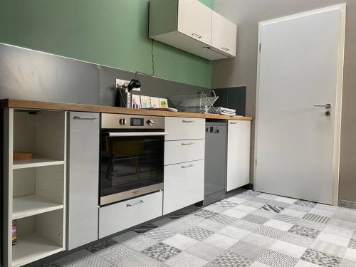 una cucina con armadi bianchi e forno di Appartement proximité centre a Mulhouse