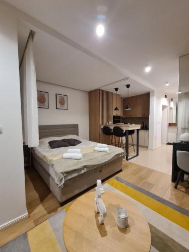 - une chambre avec un lit et une table dans l'établissement Apartmani Central 4 & Free parking, à Vrnjačka Banja