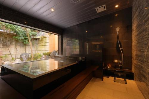 a large bathroom with a shower and a sink at Arima Onsen Taketoritei Maruyama in Kobe