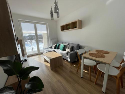 a living room with a couch and a table at Vip Apartament LAUROWA in Tyczyn
