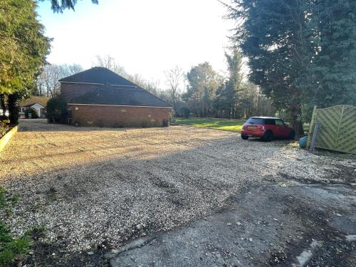 a driveway with a red car parked in front of a building at Da Vinci Guest House & Guest Parking, A Real Gem in Crawley