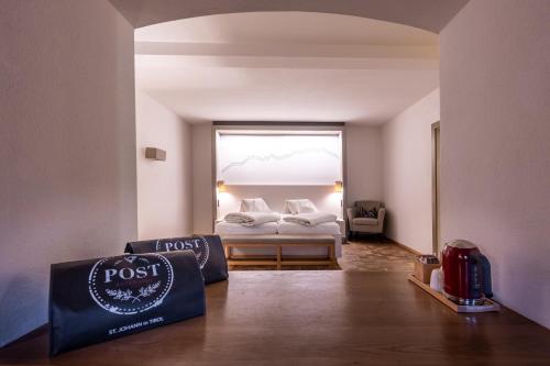 a hotel room with a bed and a window at Hotel Wirtshaus Post in Sankt Johann in Tirol