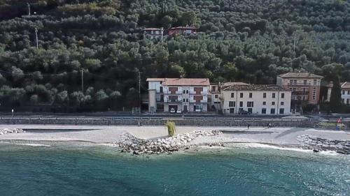 a group of buildings on a beach next to the water at Haus and Beach in Brenzone sul Garda