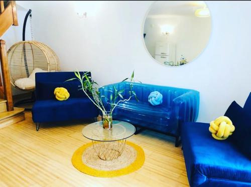 uma sala de estar com um sofá azul e uma mesa de vidro em cosy studio design with modern bathroom em Vauréal