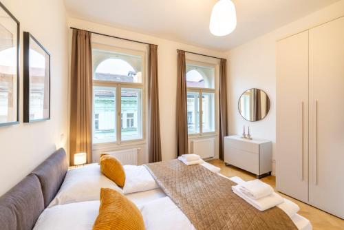 a living room with a couch and two windows at Petrin Tower Residence in Prague