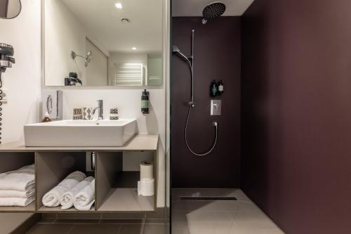 a bathroom with a sink and a shower at Hotel Wirtshaus Post in Sankt Johann in Tirol