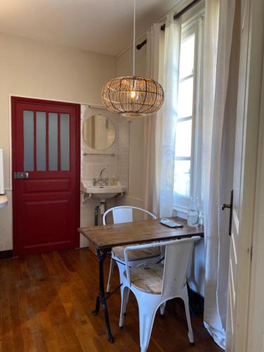 a dining room with a table and chairs and a red door at Château La Barge - Dordogne in La Boissière-dʼAns