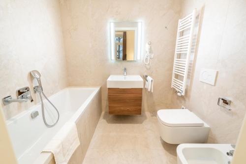 a bathroom with a tub and a sink and a toilet at Petrin Tower Residence in Prague