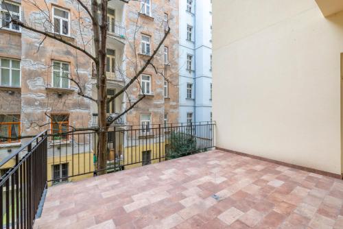 a balcony with a tree and a building at Petrin Tower Residence in Prague